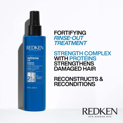 Blue bottle of Redken hair treatment with bold text about strengthening damaged hair and rebuilding.