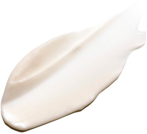 En klick vit kräm eller lotion utbredd på en vit bakgrund.
