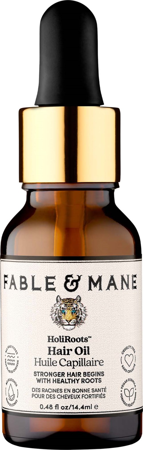 Fable & Mane Hair Oil in a small amber glass bottle with a black dropper cap, label shows product details.