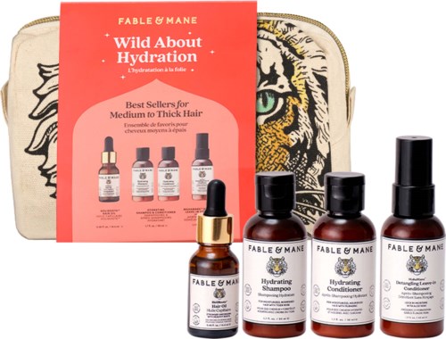 A set of Fable & Mane hair products including shampoo, conditioner, leave-in treatment, and a small bottle with a dropper, in front of a tiger face design bag.