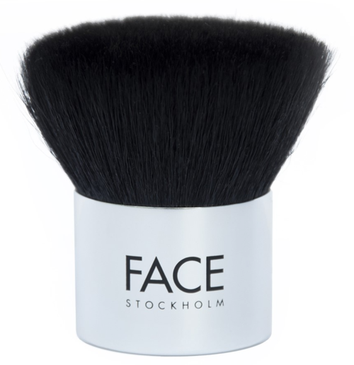 En stor svart makeupborste med vitt handtag där det står 'FACE STOCKHOLM.'
