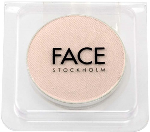 En rund pressad puderprodukt i ett genomskinligt plastfodral med etiketten 'FACE STOCKHOLM'.