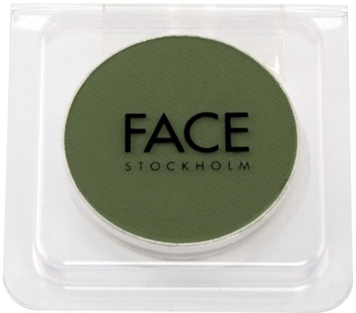 Ett runt grönt makeup-produk inuti ett plastfodral med orden "FACE STOCKHOLM" skrivet på det.
