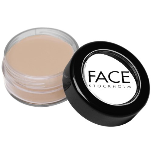 En beholder med beige creme med sort låg mærket 'FACE STOCKHOLM'.