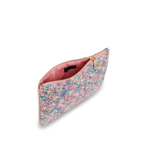 En blommig mönstrad dragväska med rosa insida, visar ett öppet drag och en svart etikett inuti.