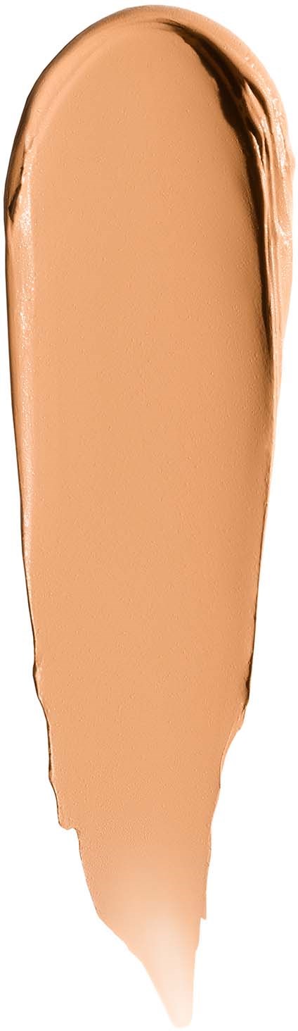 Beige nestemäinen neste, jossa tummempi reuna, levittyy pitkänomaisena valkoiselle taustalle.