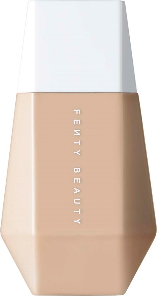 En beige flaska märkt 'Fenty Beauty' med vit kork, sannolikt en kosmetikprodukt.