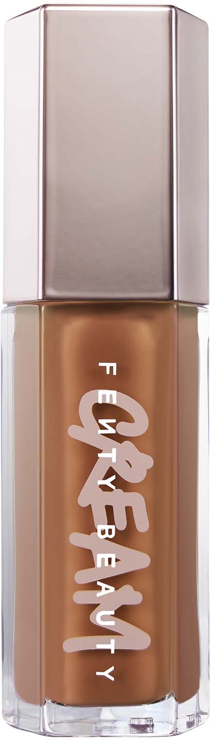 En flaska av Fenty Beauty-foundation med silverlock och beige vätska inuti.