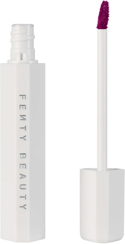 A white lip gloss container with the applicator stick beside it, showing a dark purple gloss.