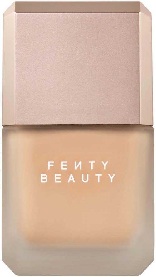 Fenty Beauty foundationflaska med beige lock och genomskinligt glas som visar ljusbeige produkt inuti.