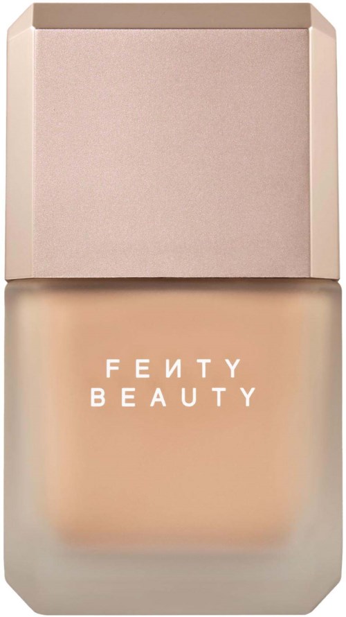 Fenty Beauty foundationflaska med ljusrosa lock och beige etikett.