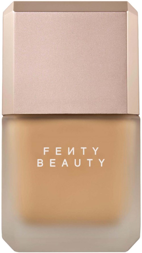 Fenty Beauty-foundationsflaska med ljusrosa lock och beige vätska inuti.