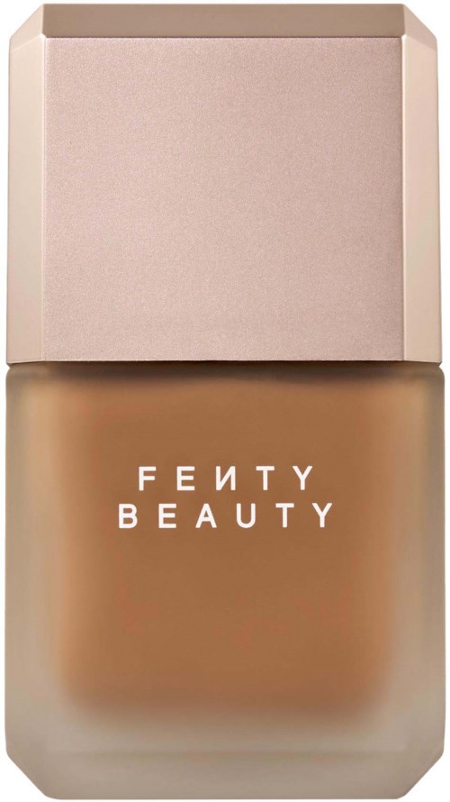 Fenty Beauty foundationflaska med ett ljusrosa lock och brunt innehåll.