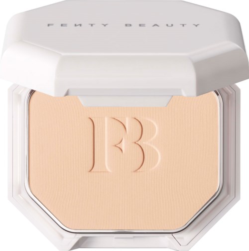 Ett kompakt med ett beige puder och embossat 'FB'-logo, märkt 'Fenty Beauty', i ett vitt fall.