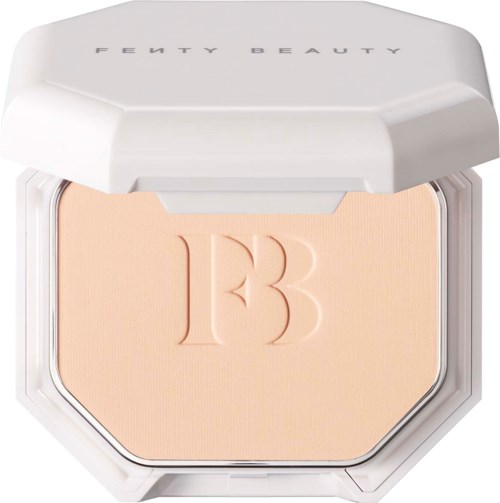 En kompakt med en beige puder och präglad '13' inuti, i ett vitt skal märkt Fenty Beauty.