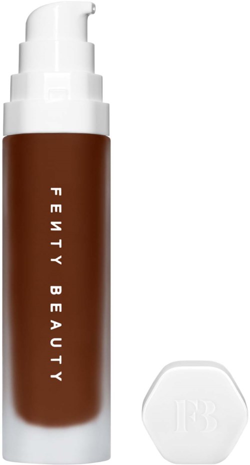 Buteleczka brązowego podkładu w płynie z białym dozownikiem i zakrętką, oznaczona 'Fenty Beauty' oraz biały gąbkowy aplikator.