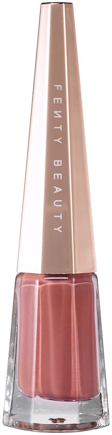 En nagellackflaska med rosa nyans och ett långt, guldlock som säger "FENTY BEAUTY."