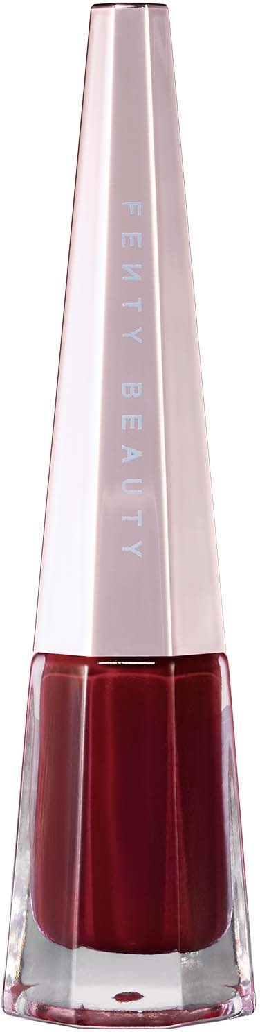 En lång, smal nagellackflaska med ett metalllock. Etiketten säger "Fenty Beauty". Rött nagellack syns inuti.