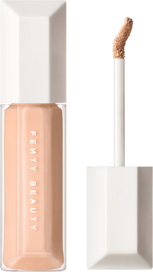 En beige flytande concealerkonsistens i en genomskinlig flaska med vit lock och applikator.