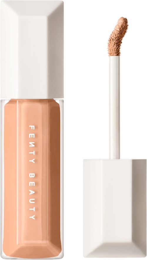 En lotionflaska med vit lock och platta, märkt 'Fenty Beauty' i vitt text, innehåller beige flytande makeup.