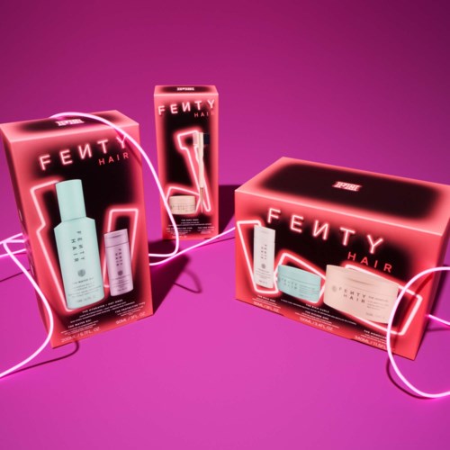 Colorful Fenty Hair product boxes with neon pink accents on purple background. Branded hair care items inside.