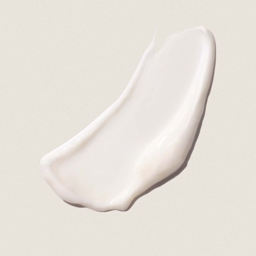 En klick vit kräm eller lotion med en slät, krökt form på en enkel bakgrund.