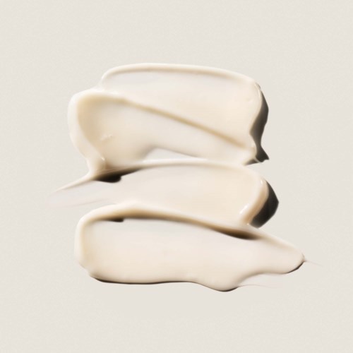 Tre vita klumpar av grädde eller yoghurt staplade på en enkel bakgrund.