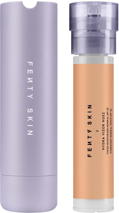 En hög, lila och genomskinlig flaska med Fenty Skin-märke, sannolikt en hudvårdsprodukt.