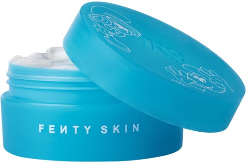 A blue jar of Fenty Skin cream with an opened lid showing white cream inside.