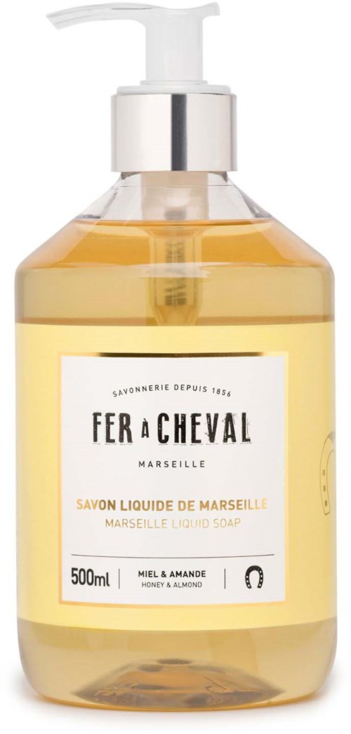 A clear bottle with a pump top containing yellow liquid soap, labeled with product details and scent, honey and almond.