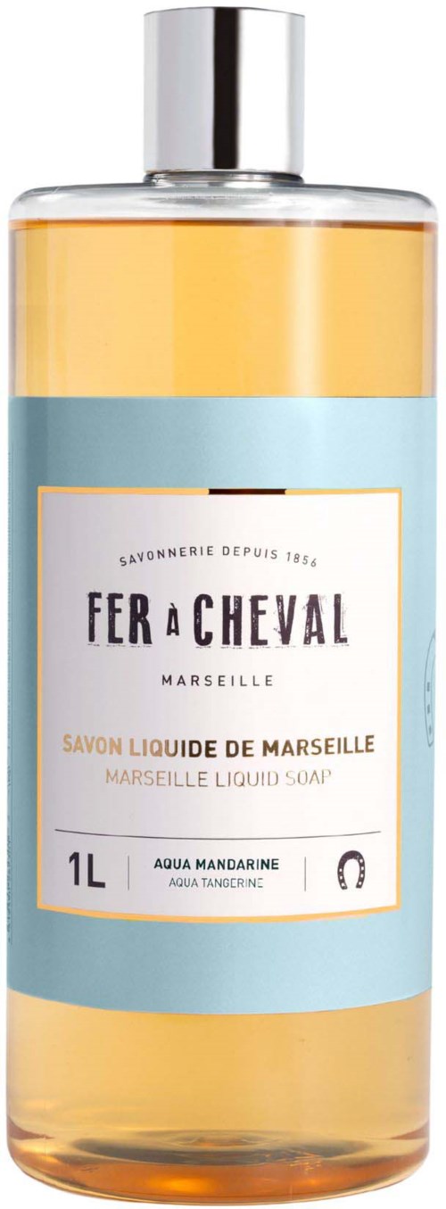 En klar flaske med oransje flytende såpe, etiketten viser merket Fer a Cheval, Marseille, 1 liter, med oransje og blå farger.
