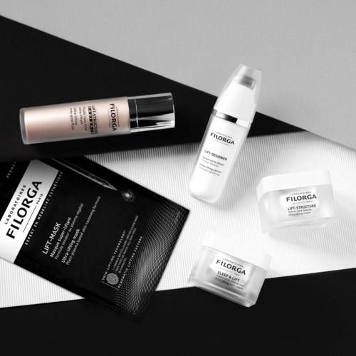 Hudpleieprodukter med etiketter, inkludert en maske, krem og flasker, arrangert på svart-hvitt bakgrunn.