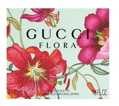 En doftkartong med blommönster i stora rosa, röda och lila blommor och gröna blad, märkt 'GUCCI FLORA'.