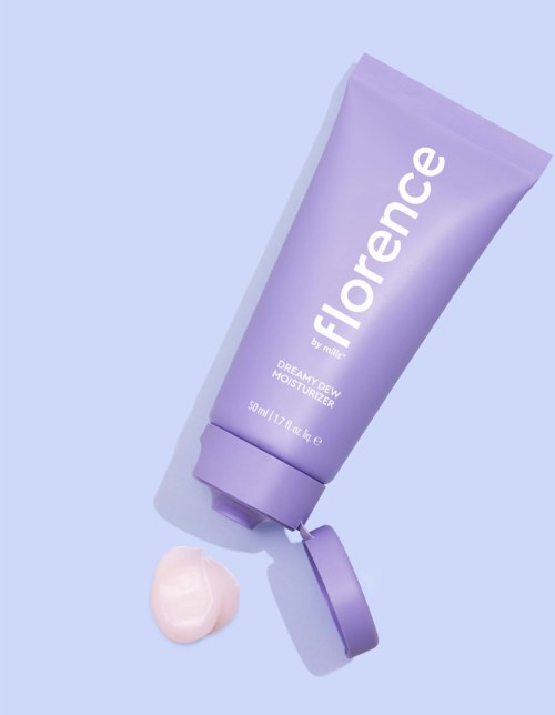 A lavender tube with a flipped cap and a small amount of cream beside it. The tube has white text on it.
