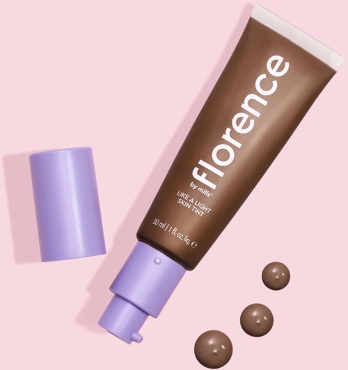 A tube of Florence skincare cream with three small dollops on a pink background.