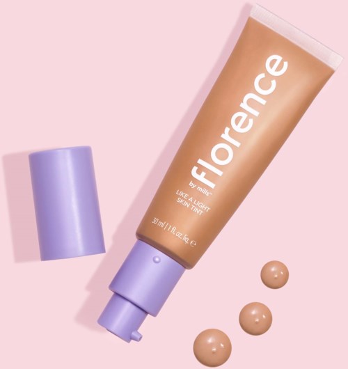 A tube of Florence sunscreen with a purple cap and three dollops of cream on a pink background.
