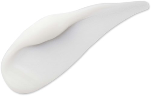 En vit kräm eller lotion utbredd på en svart bakgrund, formad som en långsträckt tår.