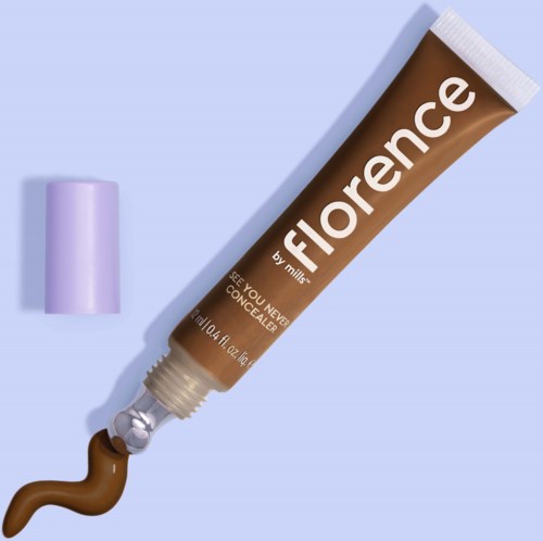 Ett brunt concealer-rör med vitt text, en lila kork och en liten mängd concealer utpressad.