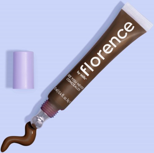 En tub märkt Florence av mille med ett lila lock, som lägger ut en brun concealer på en ljusblå bakgrund.
