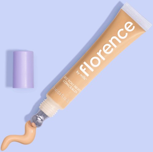 En concealer-tub med lila lock på en blå bakgrund.