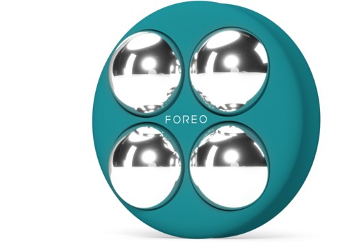 En teal enhet med fyra glänsande, silverfärgade runda bollar inuti och ordet "FOREO" i mitten.