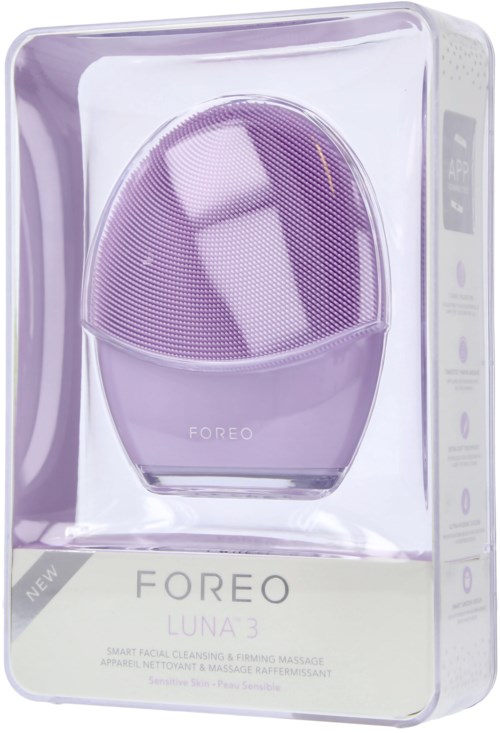En lila FOREO Luna 3 ansiktsrengöringsapparat i klar förpackning. Den har ett runt ansikte och knappar på sidan.
