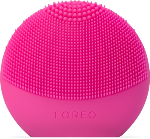 En rosa, rund hudvårdsapparat med små silikonborstar och märket 'FOREO' på.