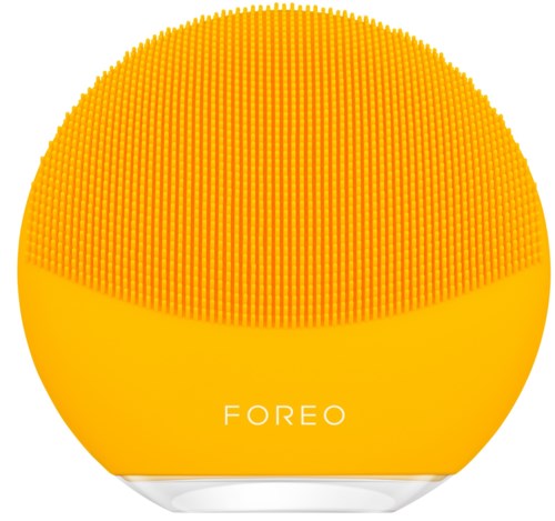 En gul rund hudplejeenhed med små gummispidser på toppen og ordet "FOREO" på.