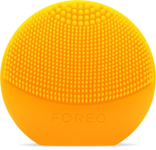En lys gul rund ansigtssenhed med en tekstureret, prikket overflade og ordet 'FOREO'.