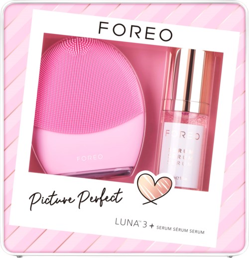 Ett rosa hudvårdsset med en silikonansiktsborste och en serumflaska i rosa förpackning.