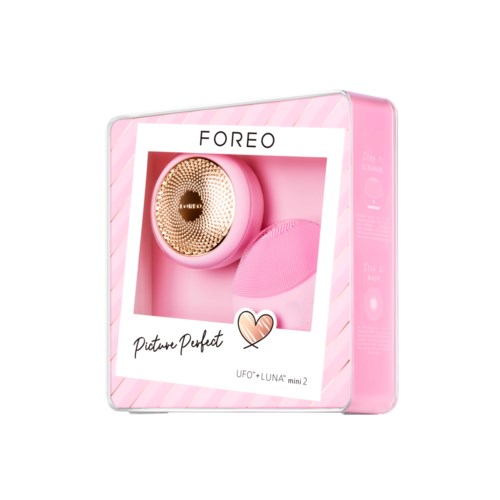 Pink skönhetsapparat med ett guldhuvud, och ett rosa silikontillbehör i lådan.
