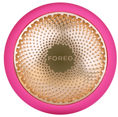 En rund enhet med rosa kant og gul, teksturert overflate som har teksten 'FOREO' i midten.