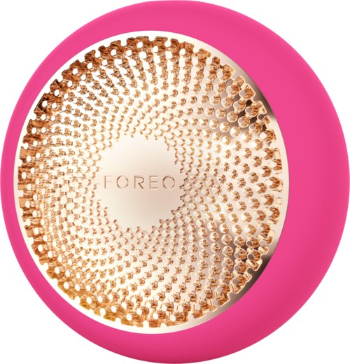 En rund enhet med rosa kant och en guldformad yta, med märket "FOREO" i mitten.