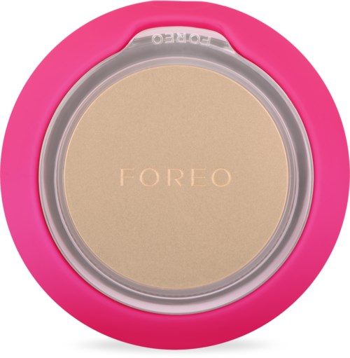 En rund beige puder i en rosa behållare med tydligt lock, märkt 'FOREO'.